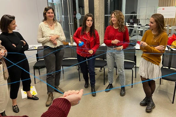 Personnes reliées par un fil de laine pendant un atelier